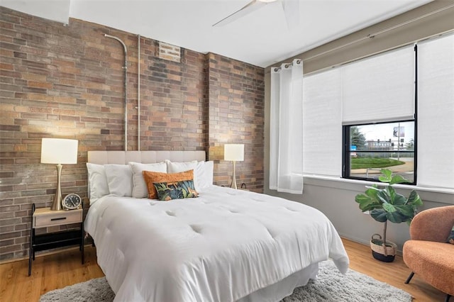 1720 Chouteau Ave Unit 110, Saint Louis, MO 63103 - bedroom featuring brick wall, wood finished floors, and ceiling fan