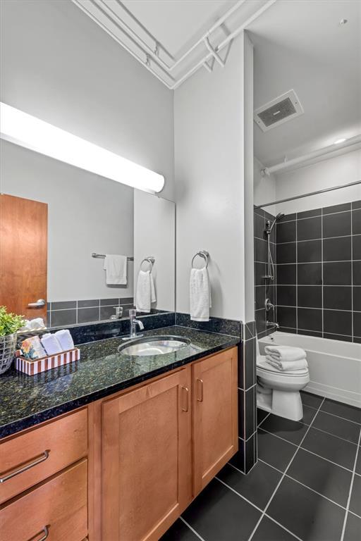 1720 Chouteau Ave Unit 110, Saint Louis, MO 63103 - full bath with vanity, toilet,  shower combination, and tile patterned floors