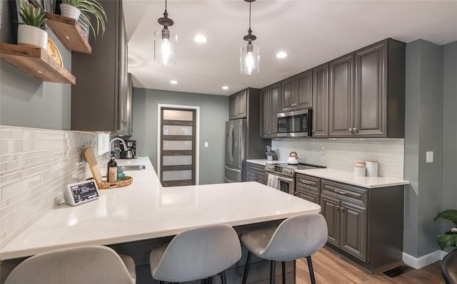 1104 Turkey Run, Rolla, MO 65401 - kitchen featuring appliances with stainless steel finishes, a sink, decorative backsplash, a breakfast bar, and recessed lighting