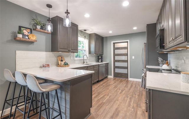 1104 Turkey Run, Rolla, MO 65401 - kitchen featuring a sink, a peninsula, appliances with stainless steel finishes, decorative backsplash, and a kitchen breakfast bar
