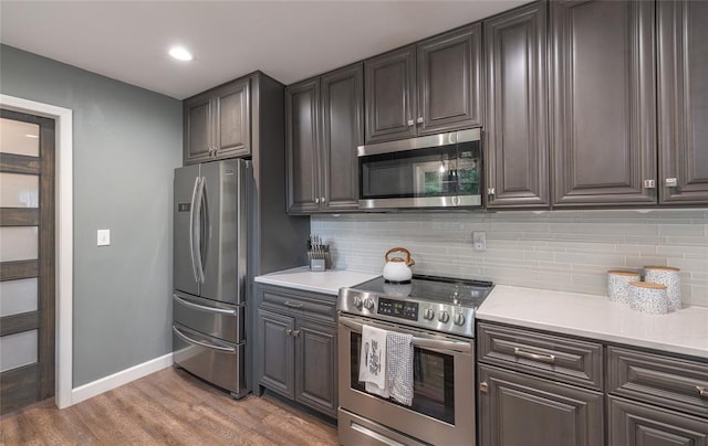 1104 Turkey Run, Rolla, MO 65401 - kitchen with stainless steel appliances, baseboards, light countertops, tasteful backsplash, and light wood-style floors