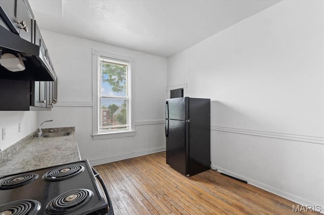 3124 Oregon Ave, Saint Louis, MO 63118 - kitchen with black appliances, a sink, light wood-style flooring, baseboards, and light countertops