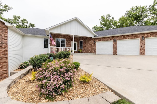 11475 Slate Cir, Rolla, MO 65401 - view of front of property with covered porch, brick siding, a garage, concrete driveway, and board and batten siding
