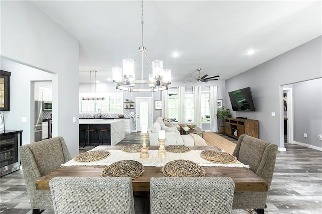 11475 Slate Cir, Rolla, MO 65401 - dining area featuring wine cooler, a chandelier, wood finished floors, ceiling fan, and recessed lighting
