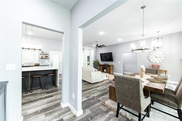 11475 Slate Cir, Rolla, MO 65401 - dining area featuring wood finished floors, a chandelier, a ceiling fan, and baseboards