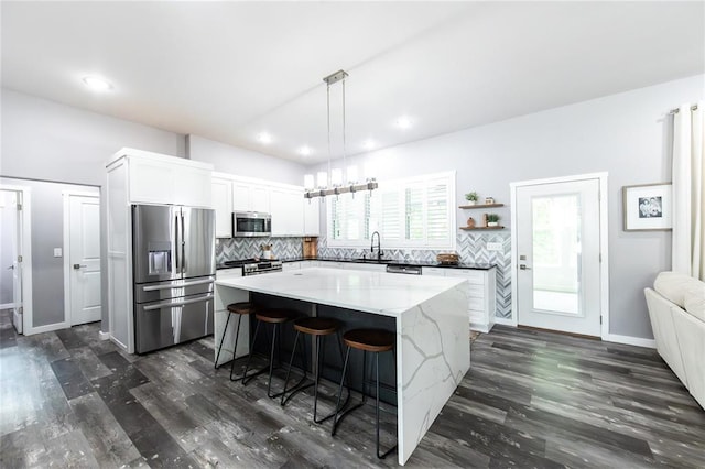 11475 Slate Cir, Rolla, MO 65401 - kitchen with stainless steel appliances, dark wood finished floors, a center island, decorative backsplash, and recessed lighting