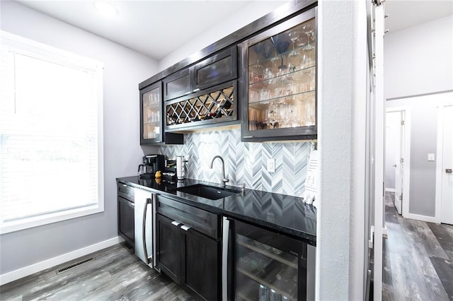 11475 Slate Cir, Rolla, MO 65401 - indoor wet bar featuring wine cooler, tasteful backsplash, dark wood-style floors, and baseboards