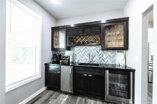 11475 Slate Cir, Rolla, MO 65401 - indoor wet bar with beverage cooler, backsplash, dark wood-style floors, and baseboards