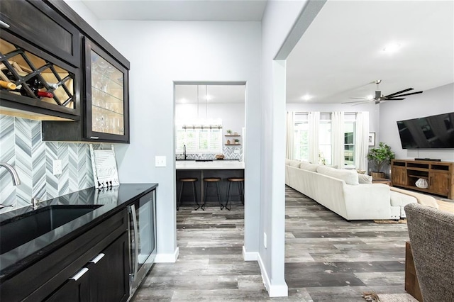 11475 Slate Cir, Rolla, MO 65401 - bar featuring a sink, wood finished floors, tasteful backsplash, and ceiling fan