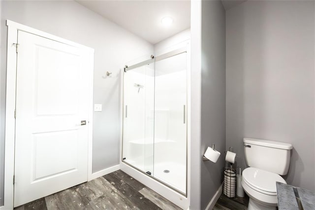 11475 Slate Cir, Rolla, MO 65401 - full bathroom featuring wood finished floors, a shower stall, toilet, and baseboards