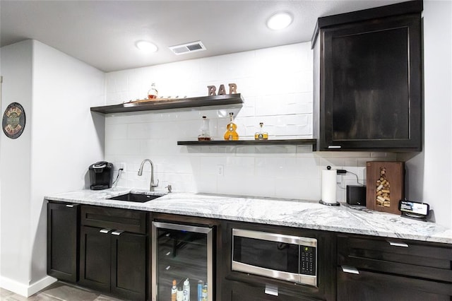 11475 Slate Cir, Rolla, MO 65401 - indoor bar featuring beverage cooler, stainless steel microwave, tasteful backsplash, and baseboards