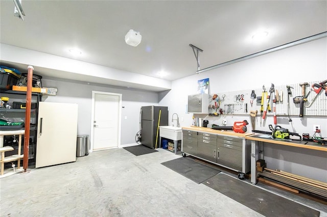11475 Slate Cir, Rolla, MO 65401 - garage featuring freestanding refrigerator and a workshop area