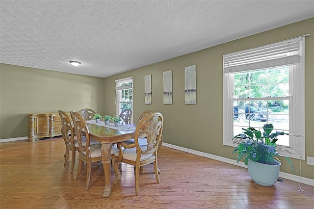 5810 Sorrel Tree Ct, Saint Louis, MO 63129 - dining area featuring wood finished floors, baseboards, and a textured ceiling