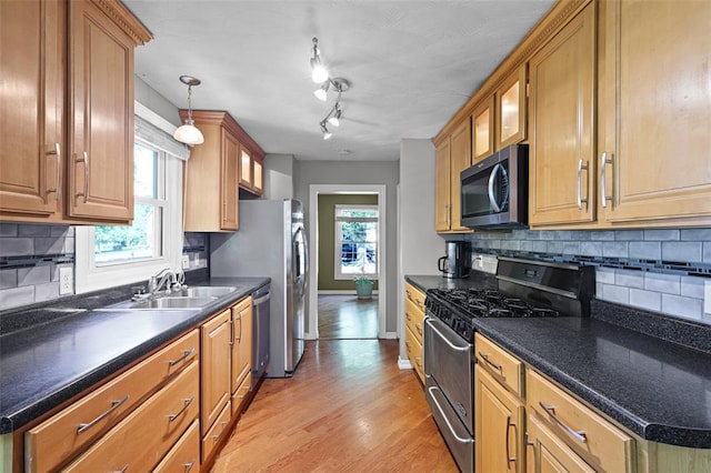 5810 Sorrel Tree Ct, Saint Louis, MO 63129 - kitchen featuring stainless steel appliances, a sink, backsplash, dark countertops, and baseboards