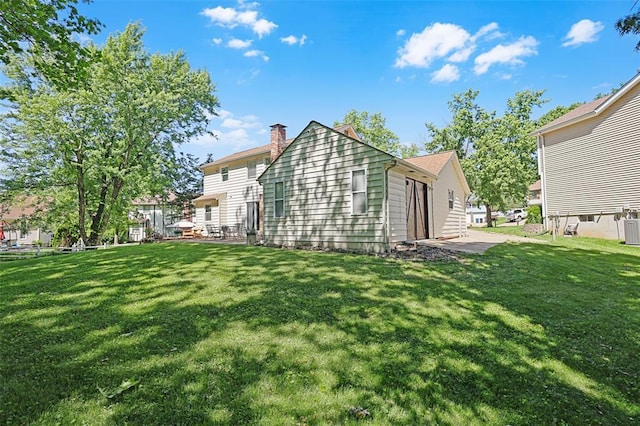 5810 Sorrel Tree Ct, Saint Louis, MO 63129 - back of property featuring a lawn, a chimney, and central air condition unit