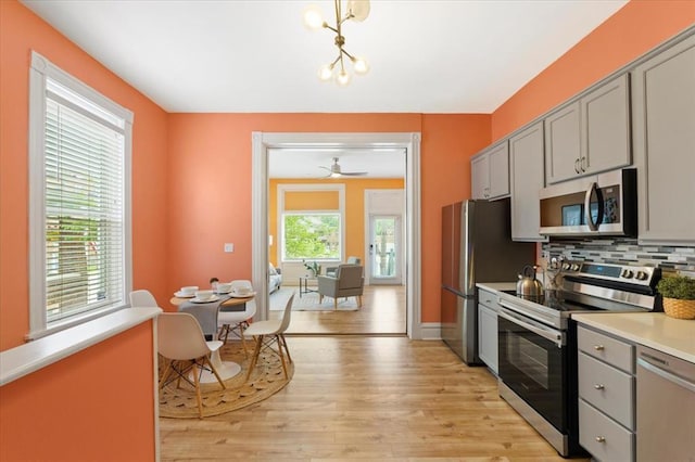 4366 Swan Ave, Saint Louis, MO 63110 - kitchen featuring stainless steel appliances, gray cabinetry, light wood-style floors, and light countertops