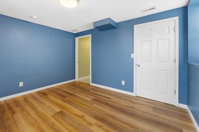 4366 Swan Ave, Saint Louis, MO 63110 - unfurnished bedroom featuring baseboards and wood finished floors