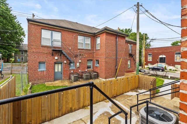 4366 Swan Ave, Saint Louis, MO 63110 - rear view of house featuring brick siding, a fenced backyard, and central air condition unit