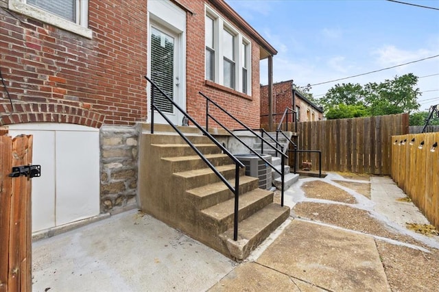 4366 Swan Ave, Saint Louis, MO 63110 - doorway to property with brick siding and central AC unit