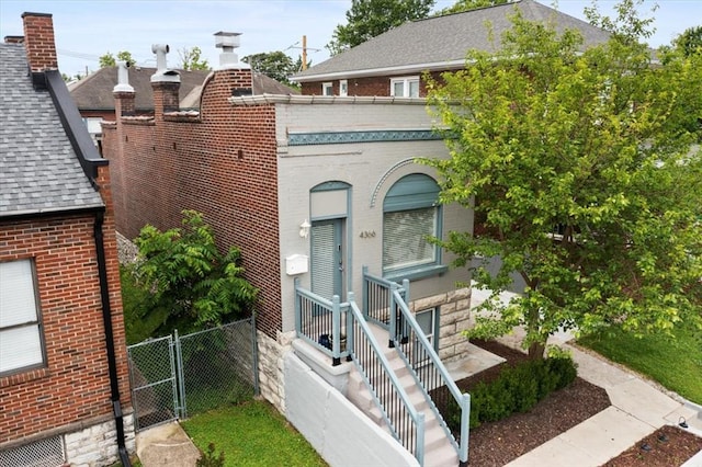 4366 Swan Ave, Saint Louis, MO 63110 - view of front of home with brick siding, a shingled roof, and a gate