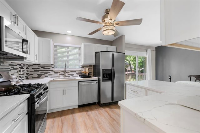 5 Braquewood Ct, Manchester, MO 63021 - kitchen featuring stainless steel appliances, a sink, backsplash, white cabinets, and a ceiling fan