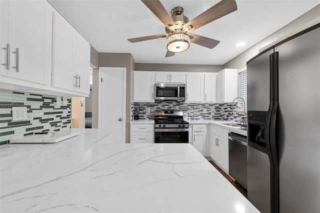 5 Braquewood Ct, Manchester, MO 63021 - kitchen featuring appliances with stainless steel finishes, a ceiling fan, tasteful backsplash, a sink, and white cabinets