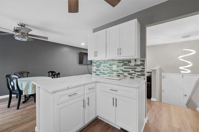 5 Braquewood Ct, Manchester, MO 63021 - kitchen with a ceiling fan, white cabinets, backsplash, light stone countertops, and a peninsula
