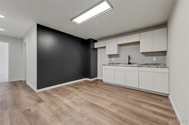 125 Foxwoods Ct, Troy, MO 63379 - kitchen with light stone counters, light wood finished floors, backsplash, white cabinetry, and recessed lighting