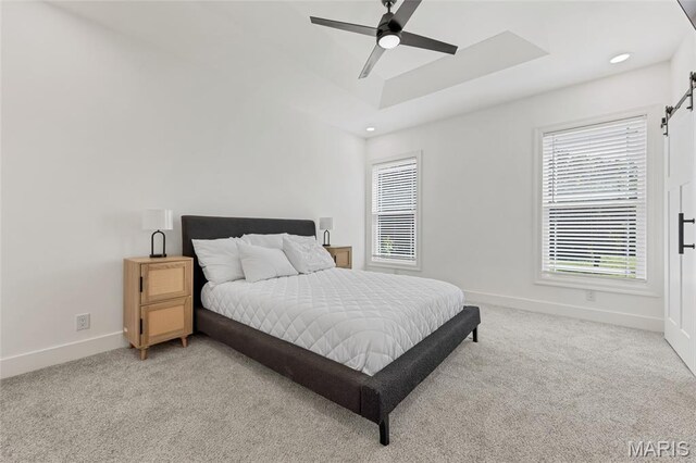 125 Foxwoods Ct, Troy, MO 63379 - bedroom with light carpet, a barn door, a ceiling fan, recessed lighting, and a tray ceiling
