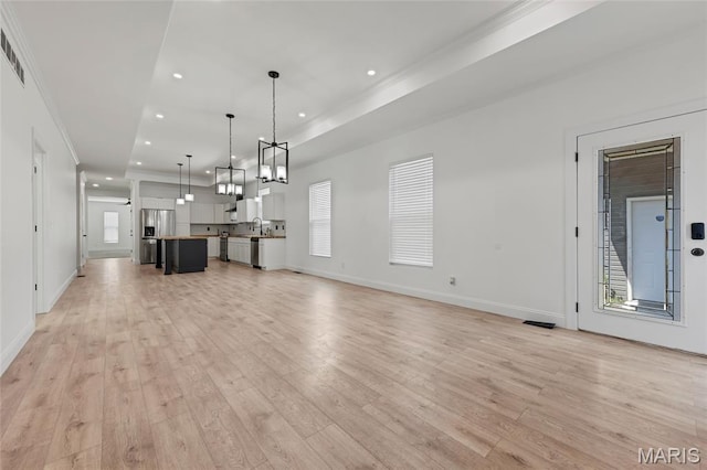 125 Foxwoods Ct, Troy, MO 63379 - unfurnished living room featuring light wood-type flooring, recessed lighting, a chandelier, and ornamental molding
