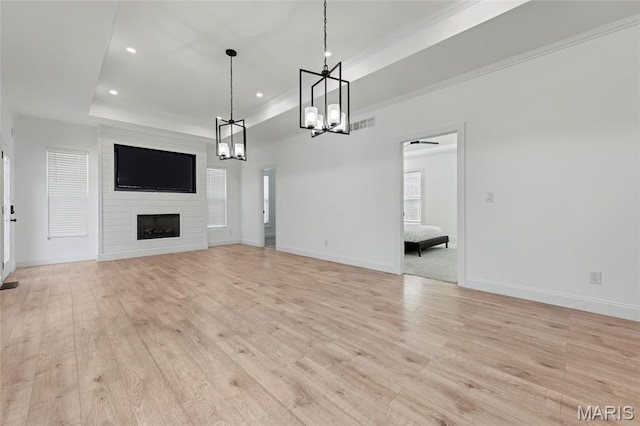 125 Foxwoods Ct, Troy, MO 63379 - unfurnished living room with light wood-type flooring, a chandelier, a fireplace, a raised ceiling, and recessed lighting