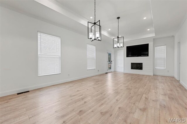 125 Foxwoods Ct, Troy, MO 63379 - unfurnished living room featuring a chandelier, recessed lighting, light wood-type flooring, a tray ceiling, and a large fireplace