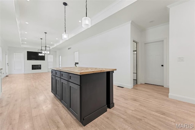 125 Foxwoods Ct, Troy, MO 63379 - kitchen with wood counters, light wood-style flooring, a fireplace, open floor plan, and recessed lighting
