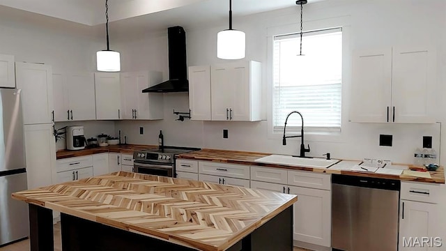 125 Foxwoods Ct, Troy, MO 63379 - kitchen featuring appliances with stainless steel finishes, wood counters, wall chimney range hood, white cabinetry, and healthy amount of natural light