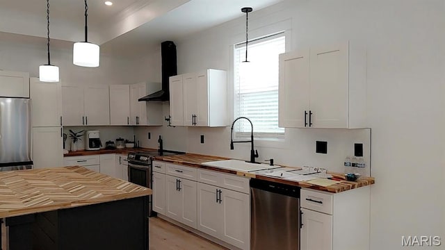 125 Foxwoods Ct, Troy, MO 63379 - kitchen with wooden counters, appliances with stainless steel finishes, wall chimney exhaust hood, white cabinetry, and recessed lighting