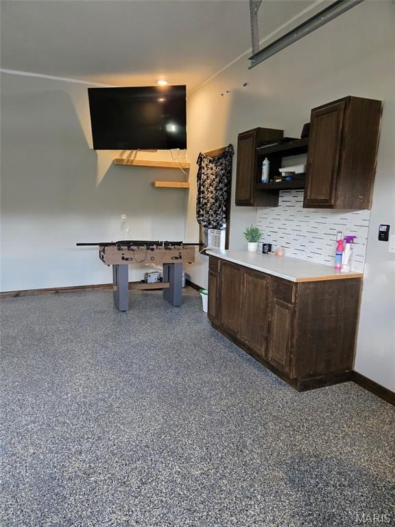 125 Foxwoods Ct, Troy, MO 63379 - kitchen with dark brown cabinetry, open shelves, light countertops, backsplash, and speckled floor