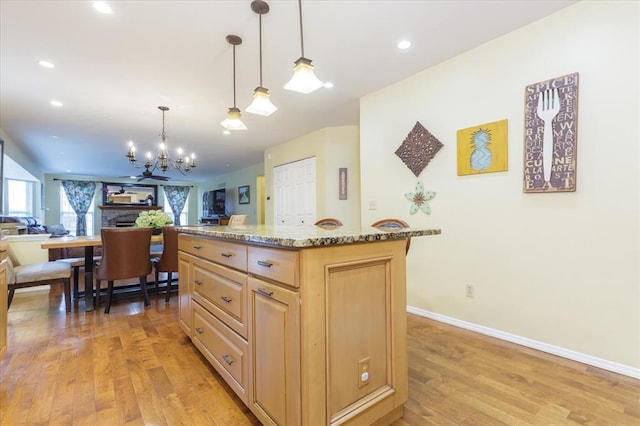 3226 Bridgeport Place Dr, Bridgeton, MO 63044 - kitchen with light brown cabinets, open floor plan, a chandelier, light wood-style flooring, and light stone countertops