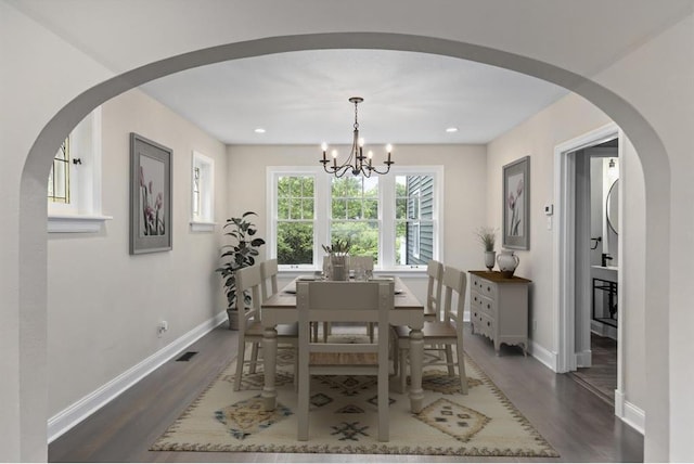 426 Pasadena Ave, Webster Groves, MO 63119 - dining space featuring a chandelier, dark wood-style flooring, baseboards, recessed lighting, and arched walkways