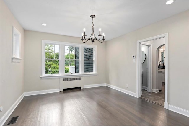 426 Pasadena Ave, Webster Groves, MO 63119 - unfurnished dining area with radiator, dark wood-style flooring, a chandelier, baseboards, and arched walkways
