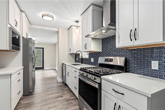 426 Pasadena Ave, Webster Groves, MO 63119 - kitchen with stainless steel appliances, wall chimney range hood, baseboards, tasteful backsplash, and white cabinets