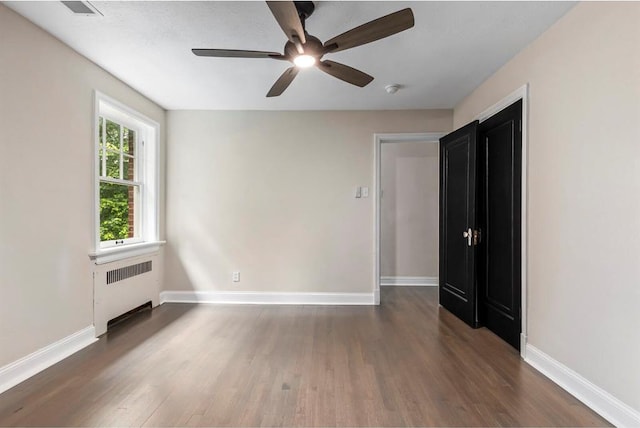 426 Pasadena Ave, Webster Groves, MO 63119 - unfurnished room featuring radiator heating unit, wood finished floors, ceiling fan, and baseboards