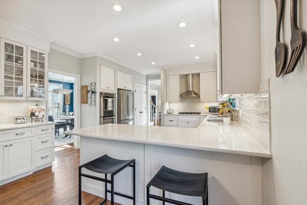 884 Craig Forest Ln, Saint Louis, MO 63122 - kitchen with appliances with stainless steel finishes, wall chimney exhaust hood, tasteful backsplash, ornamental molding, and a peninsula