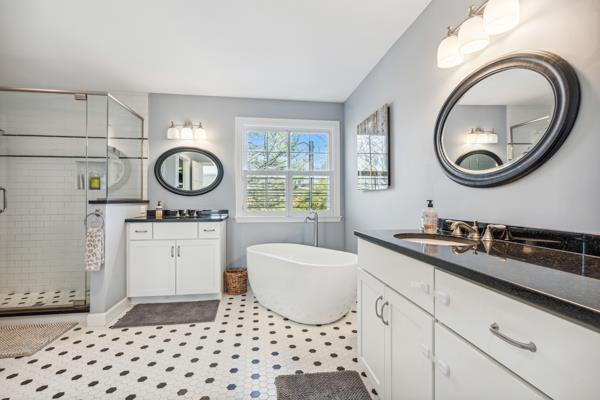 884 Craig Forest Ln, Saint Louis, MO 63122 - full bath featuring a stall shower, two vanities, a freestanding bath, and baseboards