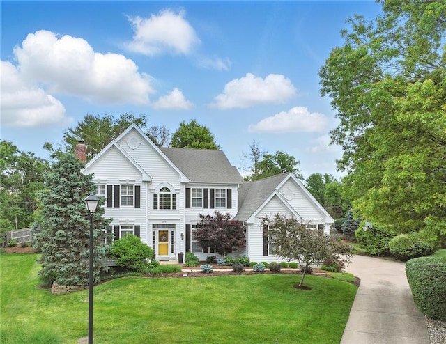 884 Craig Forest Ln, Saint Louis, MO 63122 - colonial-style house featuring a chimney, a front lawn, driveway, and a shingled roof
