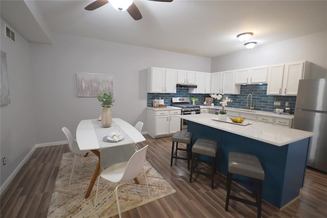 2922 Pennsylvania Ave, Saint Louis, MO 63118 - kitchen featuring appliances with stainless steel finishes, a kitchen breakfast bar, light countertops, and backsplash