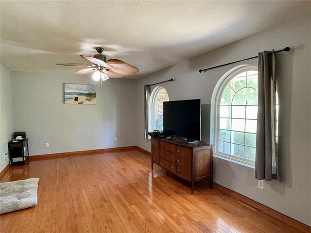 17250 Brewster Ln, Crocker, MO 65452 - unfurnished living room with light wood finished floors, a ceiling fan, and baseboards