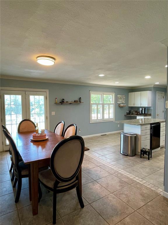 17250 Brewster Ln, Crocker, MO 65452 - dining room with baseboards, ornamental molding, a textured ceiling, light tile patterned flooring, and recessed lighting