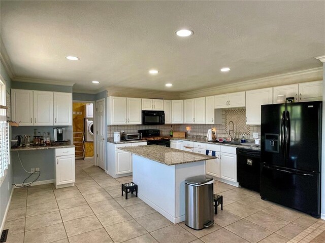 17250 Brewster Ln, Crocker, MO 65452 - kitchen with black appliances, a sink, crown molding, washer / dryer, and backsplash
