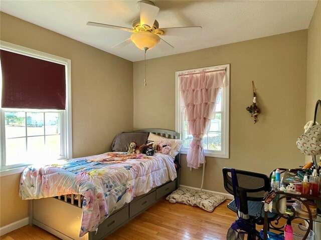 17250 Brewster Ln, Crocker, MO 65452 - bedroom with multiple windows, wood finished floors, and baseboards