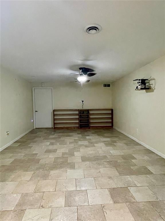 17250 Brewster Ln, Crocker, MO 65452 - spare room featuring baseboards, light stone finish flooring, and a ceiling fan